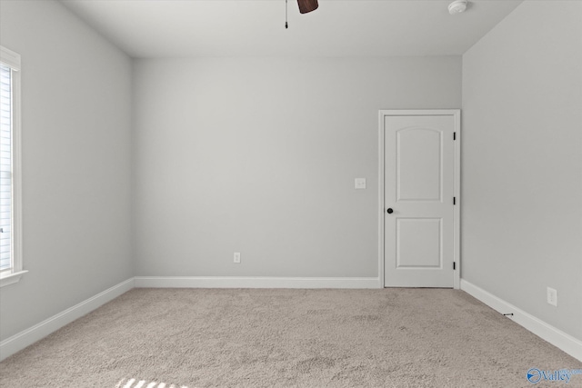 carpeted empty room featuring ceiling fan and plenty of natural light