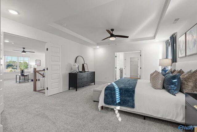 bedroom featuring ceiling fan, a raised ceiling, and carpet