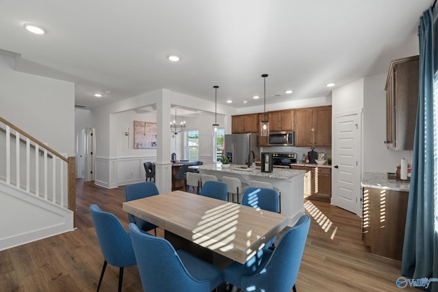 dining space featuring sink, dark hardwood / wood-style flooring, and a chandelier