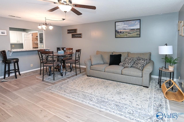 4967 Seven Pine Cir Unit 4967, Huntsville, AL 35816 - living room featuring light wood-style flooring, a ceiling fan, baseboards, and a chandelier