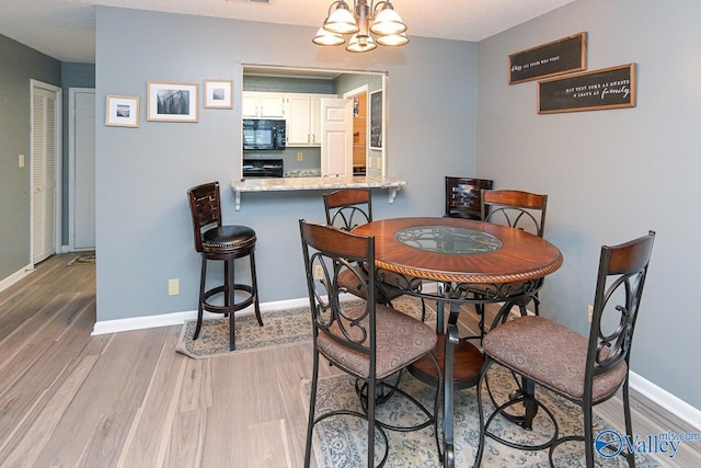 4967 Seven Pine Cir Unit 4967, Huntsville, AL 35816 - dining room with light wood-type flooring, a chandelier, and baseboards
