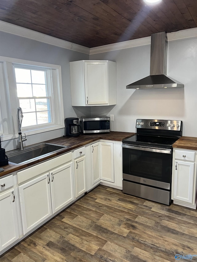 kitchen with wall chimney exhaust hood, butcher block countertops, wood ceiling, appliances with stainless steel finishes, and ornamental molding