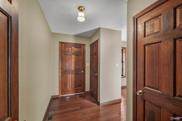 entryway featuring a textured ceiling and dark hardwood / wood-style floors