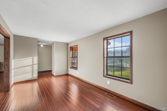 empty room featuring wood-type flooring and a textured ceiling