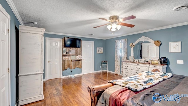 bedroom with hardwood / wood-style flooring, crown molding, ceiling fan, and a textured ceiling