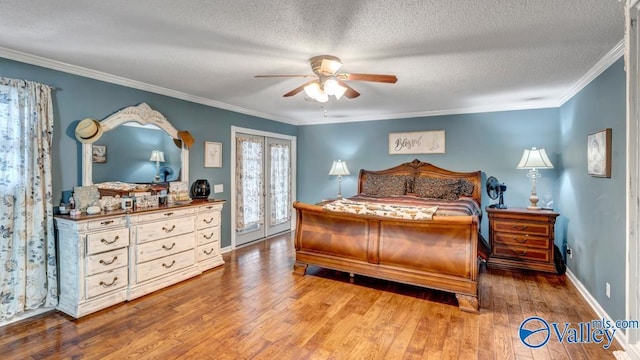 bedroom featuring hardwood / wood-style floors, ornamental molding, ceiling fan, a textured ceiling, and french doors