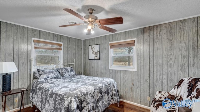 bedroom featuring multiple windows, ornamental molding, and a textured ceiling