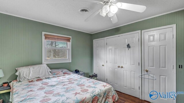 bedroom with crown molding, dark hardwood / wood-style flooring, a closet, and a textured ceiling