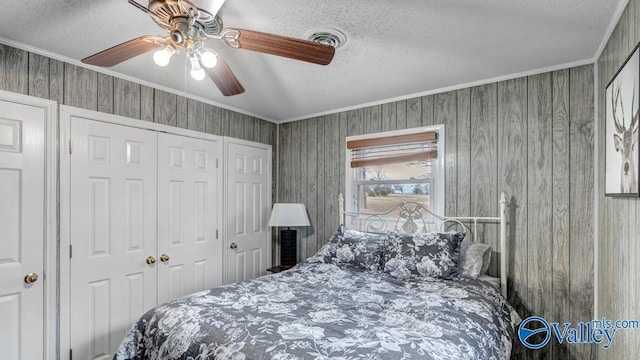 bedroom featuring ceiling fan, a closet, ornamental molding, and a textured ceiling