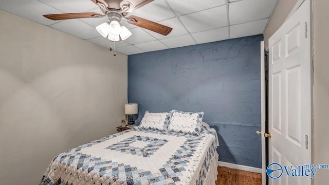 bedroom featuring ceiling fan, a paneled ceiling, and hardwood / wood-style floors