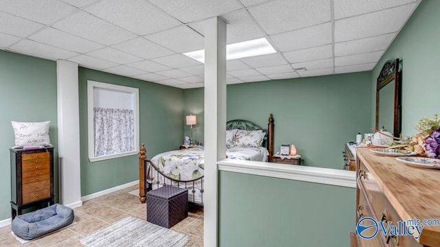 tiled bedroom featuring a paneled ceiling