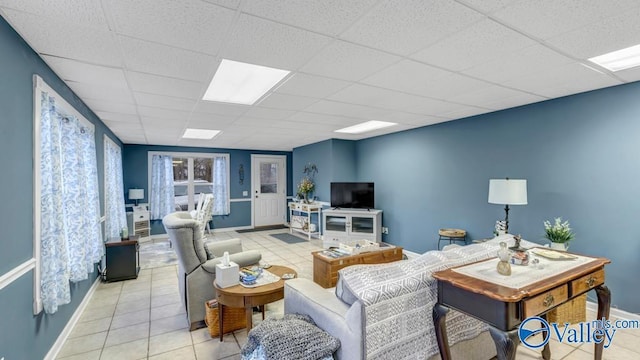 tiled living room featuring a drop ceiling