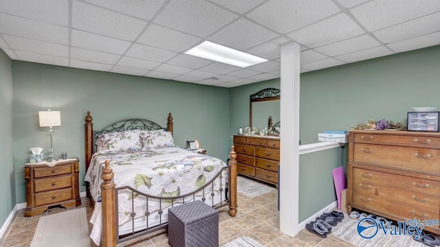 bedroom featuring light tile patterned floors and a drop ceiling