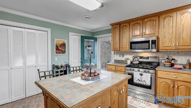 kitchen featuring backsplash, ornamental molding, stainless steel appliances, and a center island