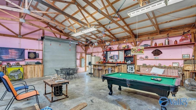 game room featuring vaulted ceiling, concrete floors, pool table, electric panel, and bar area