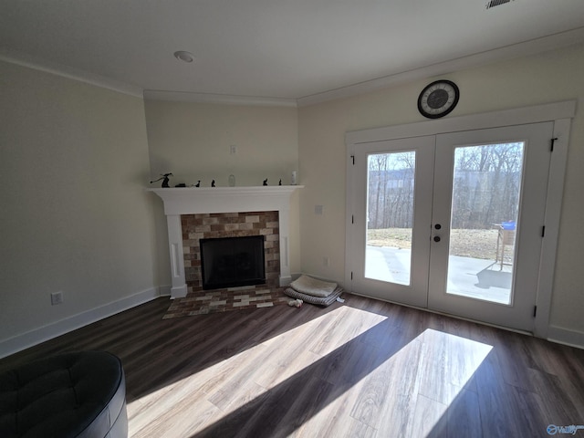 living room with a brick fireplace, hardwood / wood-style flooring, french doors, and ornamental molding