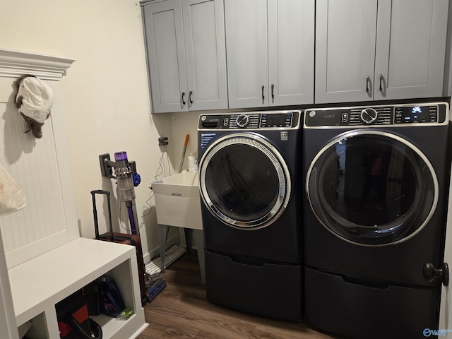 laundry room with cabinets, independent washer and dryer, and dark hardwood / wood-style flooring