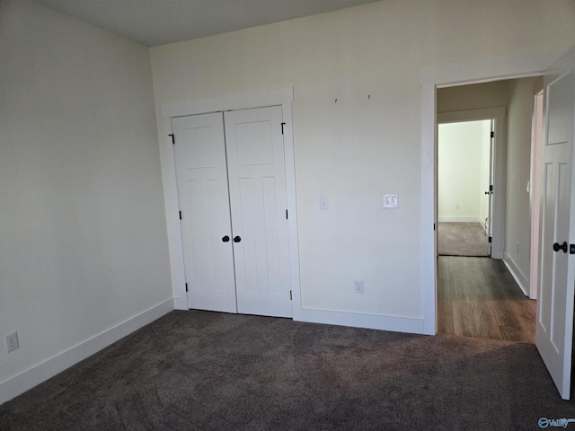 unfurnished bedroom with a closet and dark carpet