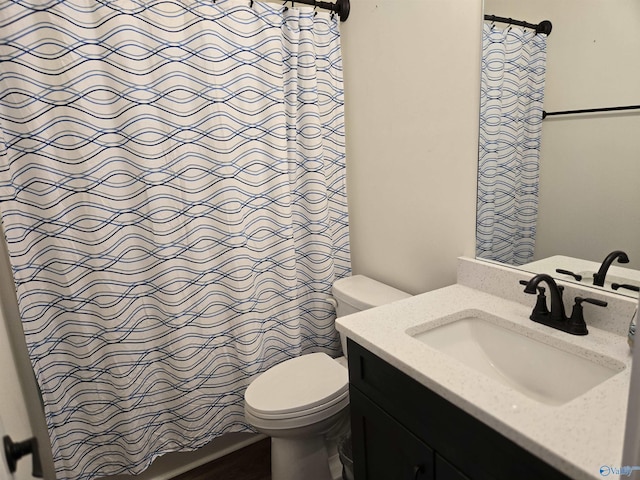 bathroom with walk in shower, vanity, and toilet