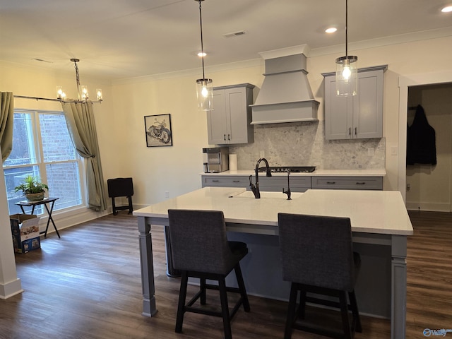 kitchen featuring gray cabinetry, pendant lighting, custom range hood, and dark wood-type flooring