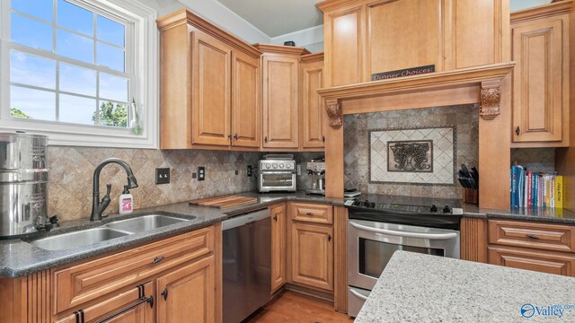 1943 Old Big Cove Rd SE, Owens Cross Roads, AL 35763 - kitchen featuring appliances with stainless steel finishes, a sink, tasteful backsplash, crown molding, and dark stone countertops