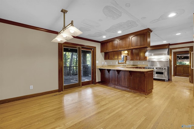 kitchen featuring high end stainless steel range, light hardwood / wood-style flooring, wall chimney exhaust hood, kitchen peninsula, and ornamental molding