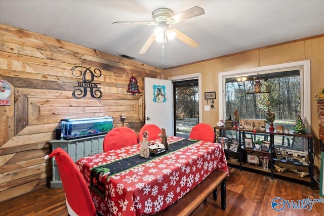 dining space with wood walls, dark hardwood / wood-style floors, and ceiling fan