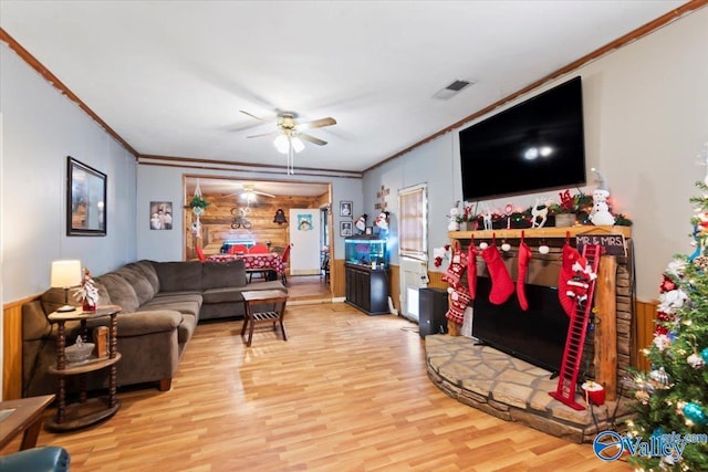 living room with hardwood / wood-style flooring, ceiling fan, and ornamental molding