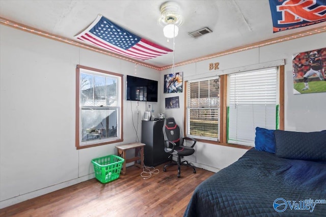 bedroom featuring wood-type flooring, ceiling fan, and crown molding