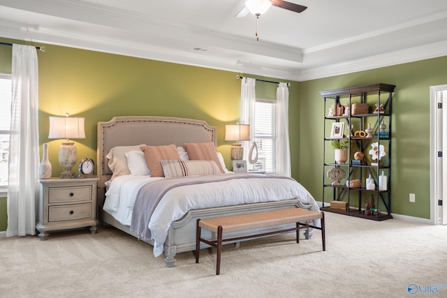 bedroom featuring crown molding, light colored carpet, a raised ceiling, and ceiling fan