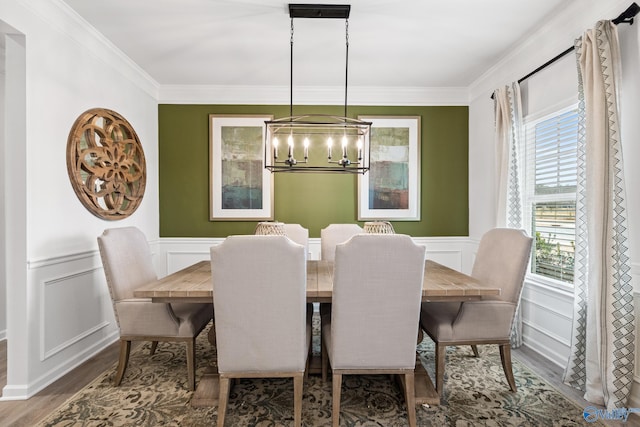 dining space featuring crown molding, hardwood / wood-style floors, and a chandelier