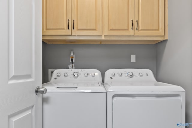 laundry room with independent washer and dryer and cabinets