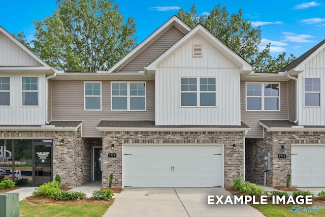 townhome / multi-family property with a garage, brick siding, board and batten siding, and driveway