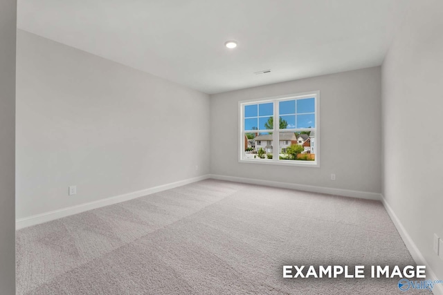 carpeted empty room with recessed lighting, visible vents, and baseboards