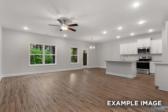 kitchen with recessed lighting, a sink, appliances with stainless steel finishes, open floor plan, and ceiling fan with notable chandelier