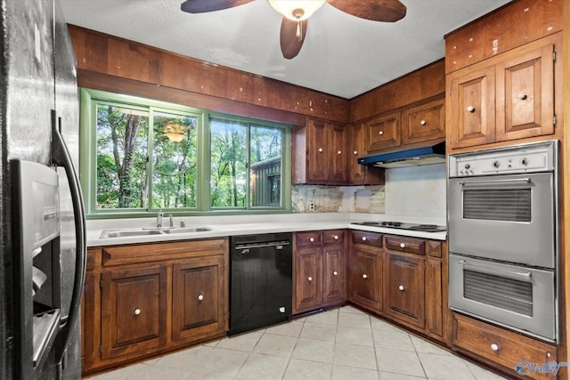 10101 Westleigh Dr, Huntsville, AL 35803 - kitchen with black appliances, under cabinet range hood, light tile patterned floors, light countertops, and a textured ceiling