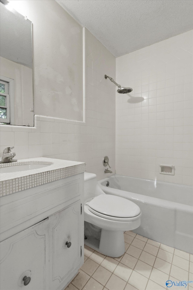 10101 Westleigh Dr, Huntsville, AL 35803 - full bath featuring tile patterned floors, vanity, tile walls, a textured ceiling, and  shower combination