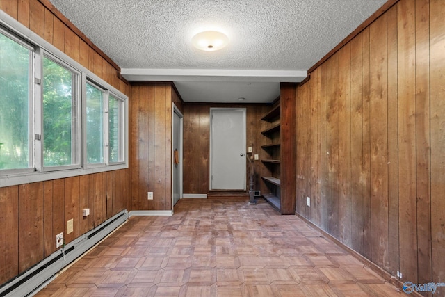 10101 Westleigh Dr, Huntsville, AL 35803 - spare room featuring baseboard heating, wood walls, a textured ceiling, and healthy amount of natural light