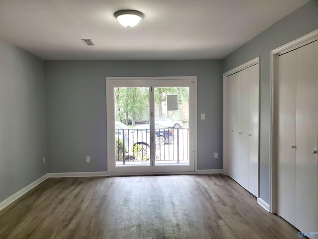 interior space with multiple closets, visible vents, light wood-style flooring, access to outside, and baseboards