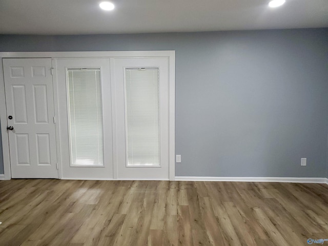 interior space featuring light wood-style flooring, baseboards, and recessed lighting