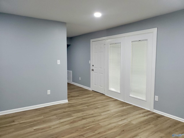 unfurnished room featuring light wood-style flooring, visible vents, and baseboards