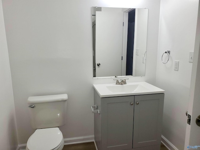 bathroom with baseboards, vanity, and toilet