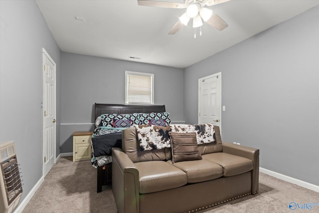 carpeted bedroom with heating unit and ceiling fan