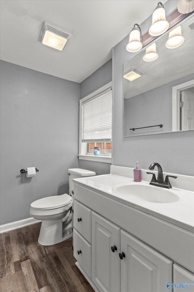 bathroom with wood-type flooring, toilet, and vanity