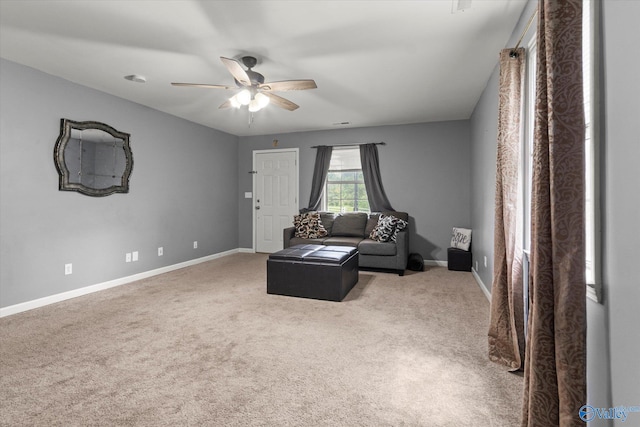 carpeted living room with ceiling fan