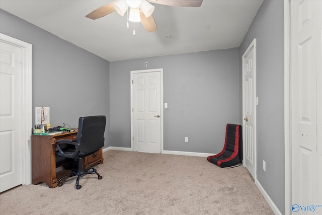 carpeted office space with ceiling fan