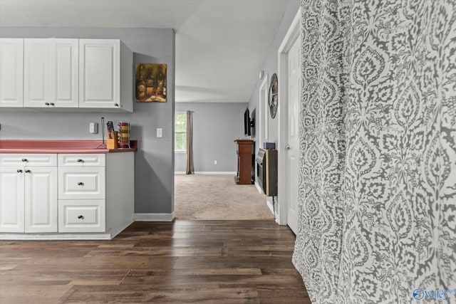 kitchen featuring dark wood-type flooring, white cabinets, and heating unit