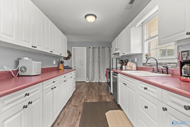 kitchen with white cabinets, dishwasher, dark hardwood / wood-style floors, and sink