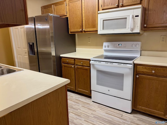 5070 Seven Pine Cir Ground, Unit Ground, Huntsville, AL 35816 - kitchen featuring white appliances, brown cabinetry, light countertops, and light wood finished floors