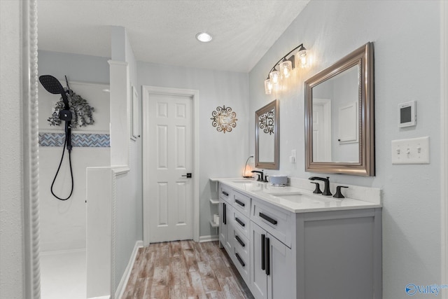 bathroom featuring vanity, walk in shower, a textured ceiling, and hardwood / wood-style floors